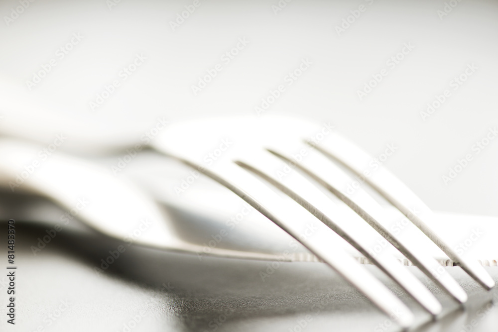 Artistic cutlery fork and knife macro on plate Artistic cutlery fork and knife macro on plate