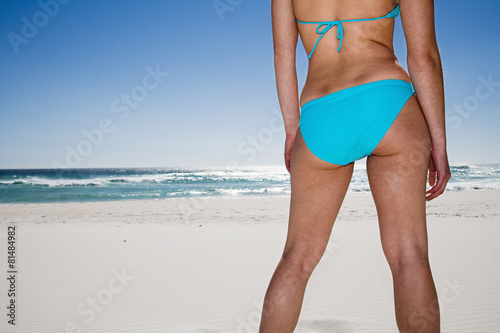 Frau steht am Strand, Rückansicht