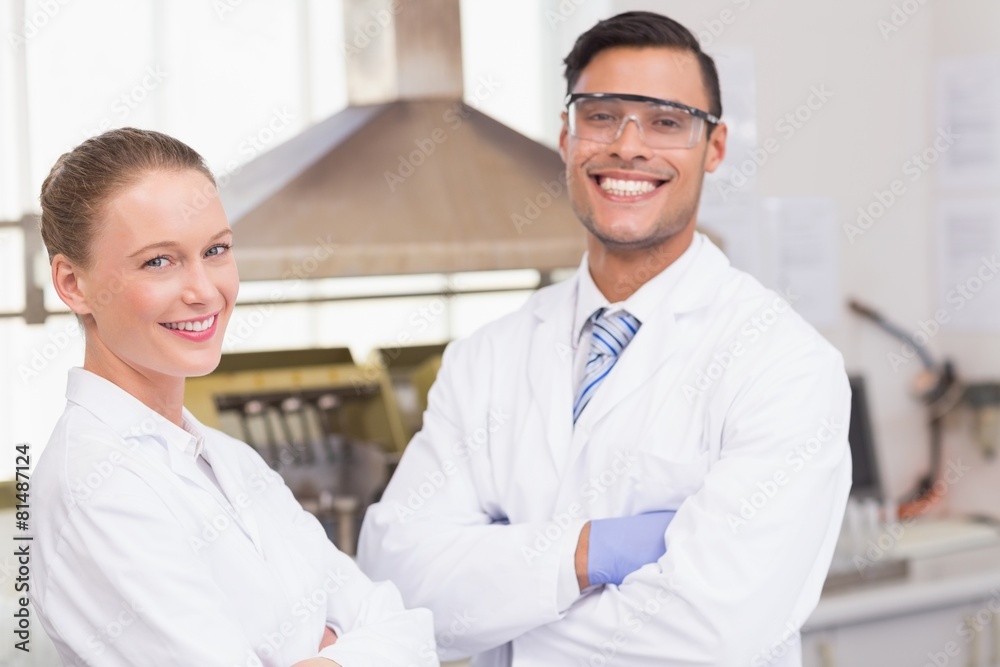 Happy scientists smiling at camera with arms crossed Happy scientists smiling at camera with arms crossed