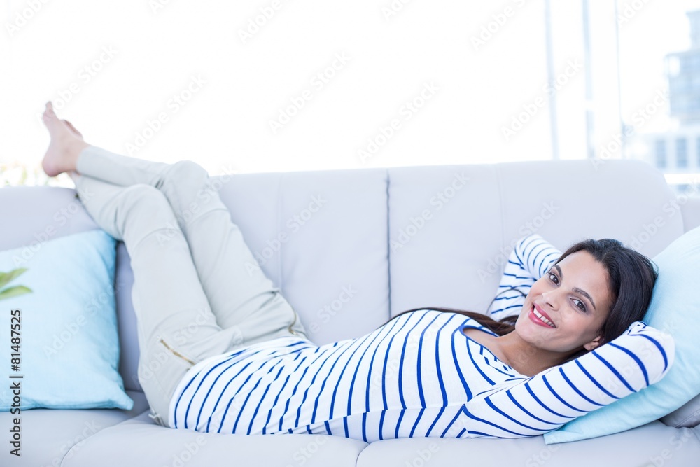 Smiling beautiful brunette relaxing on the couch Smiling beautiful brunette relaxing on the couch