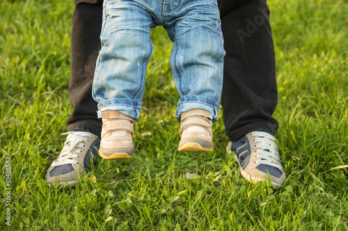 Two pairs of feet in the grass small and large