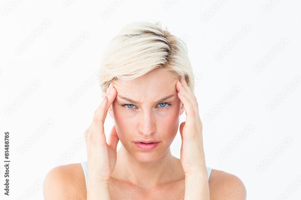 Beautiful blonde suffering from headache looking at camera Beautiful blonde suffering from headache looking at camera