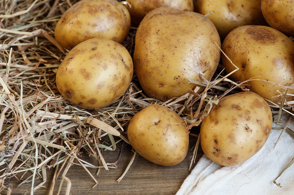 Fresh potatoes on the wooden table