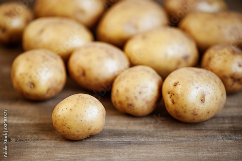 Fresh potatoes on the wooden table