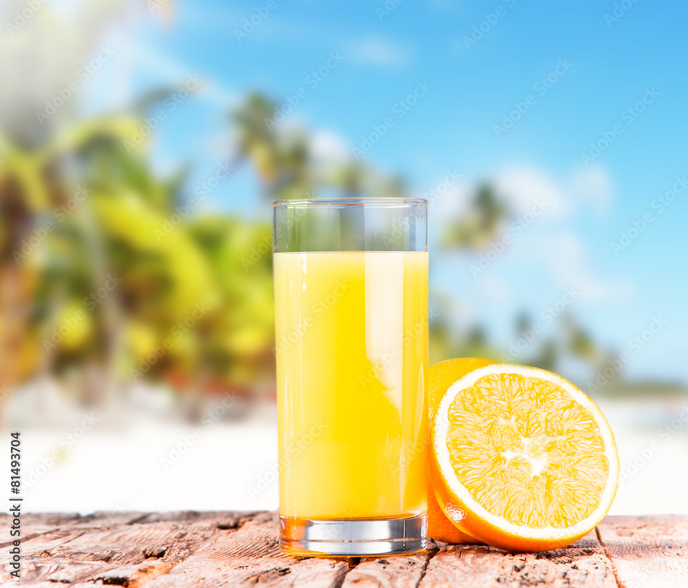 Orange juice on wooden with tropical beach Orange juice on wooden with tropical beach