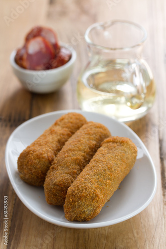 meat croquete on white dish and wine