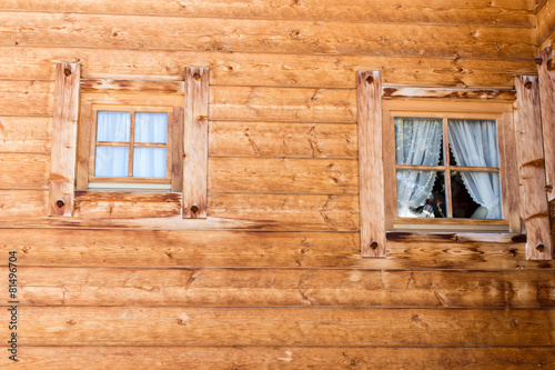 mountain cabin windows with curtains in wooden wall