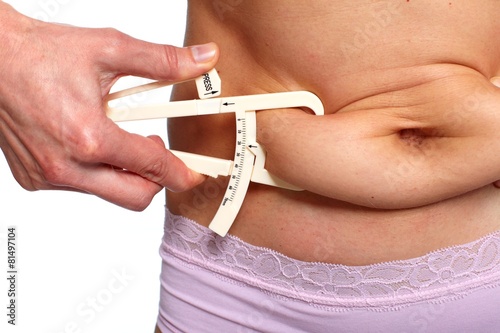 Woman measuring fat belly.