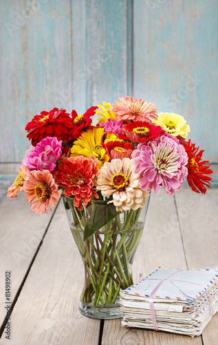 Bouquet of zinnia flowers and pile of vintage letters