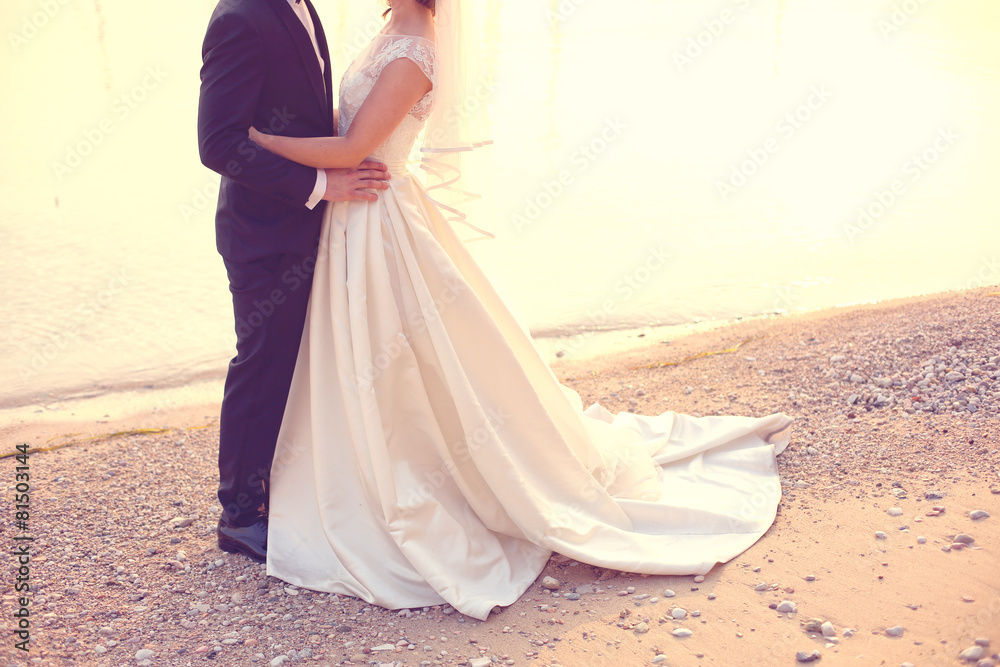 Bride and groom embracing near sea shore
Bride and groom embracing near sea shore