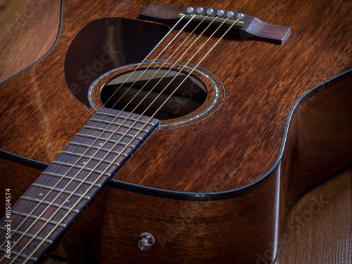 Acoustic guitar lying on the wooden floor