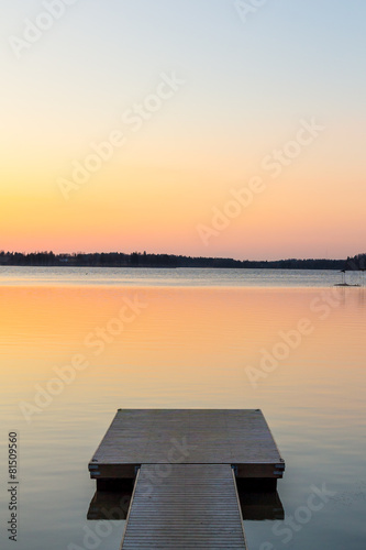 Wooden pier in the calm evening lake portrait