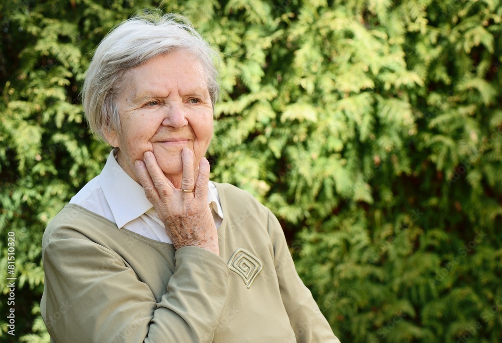 Senior woman smiling and dreaming in garden. Senior woman smiling and dreaming in garden.