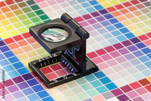 Close-up of a loupe on a colorful test print