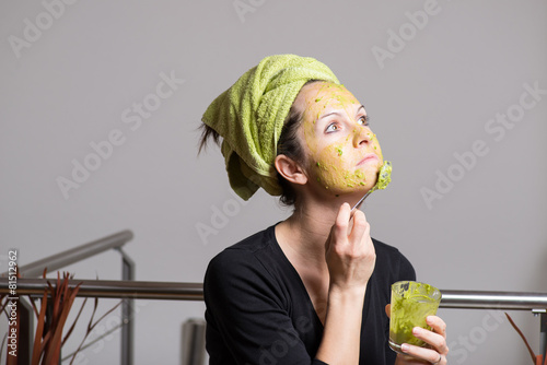 Young woman with an avocado facial mask