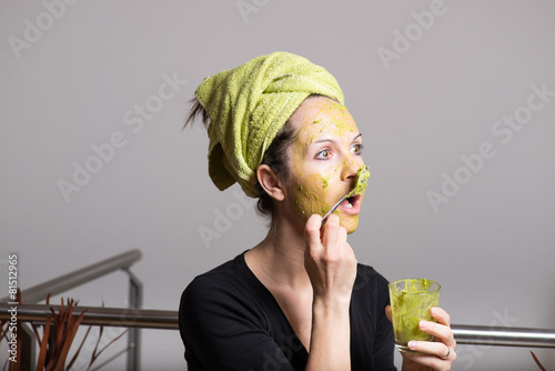 Young woman with an avocado facial mask