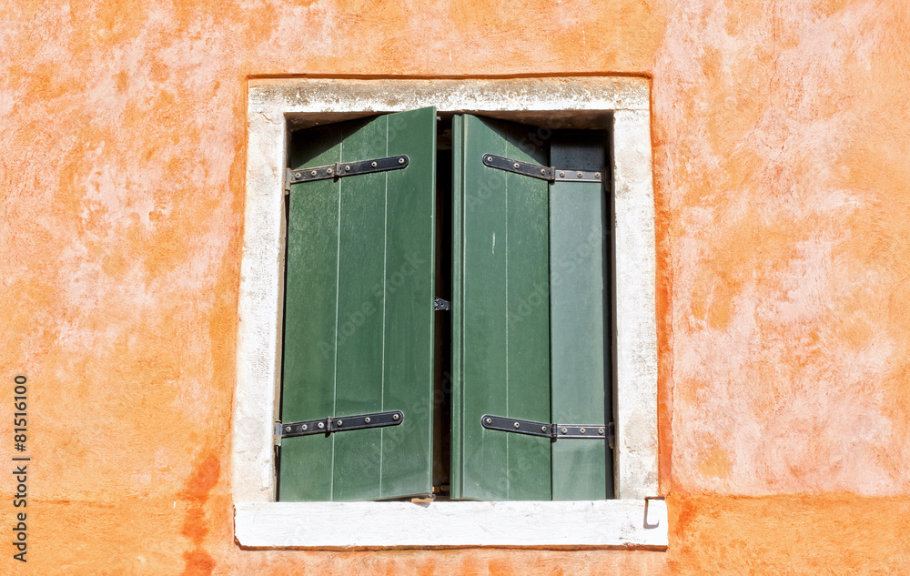 Half-closed window in a mediterranean alley
