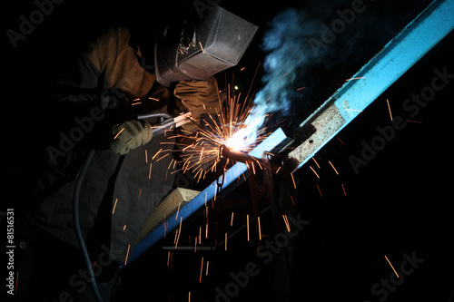 Welding operator welds metal constructions photo
