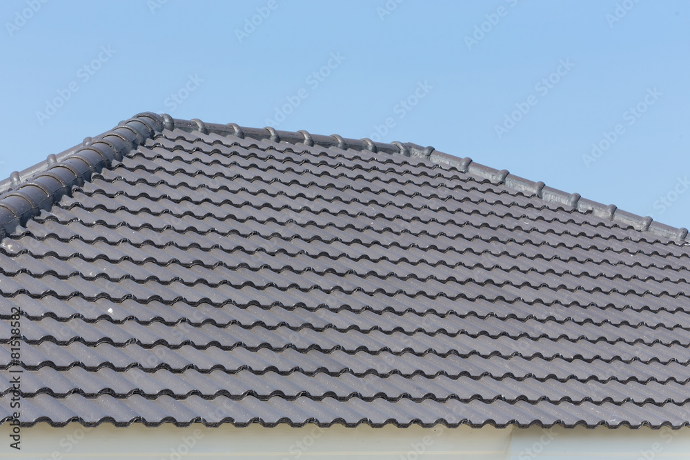 black roof tiles on house with blue sky black roof tiles on house with blue sky