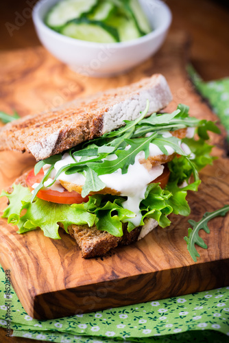 Rye toast sandwich with green leaf, tomato and chicken
