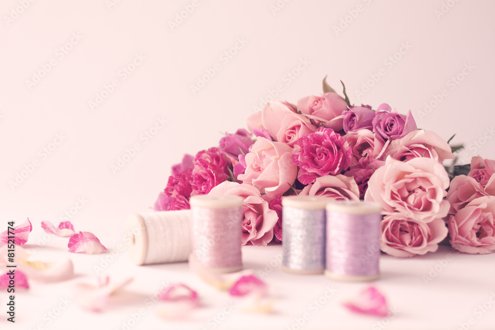 Vintage pink peonies and threads over beige background