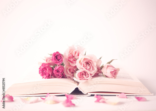 Vintage pink peonies over book over beige background