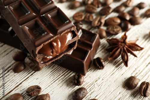 Stuffed chocolate with coffee beans on wooden table, closeup