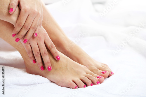 Beautiful female legs on towel, on light background