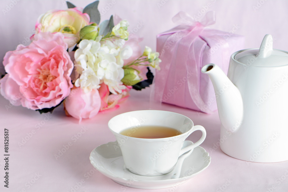 Lovely flowers with gift and cup of tea