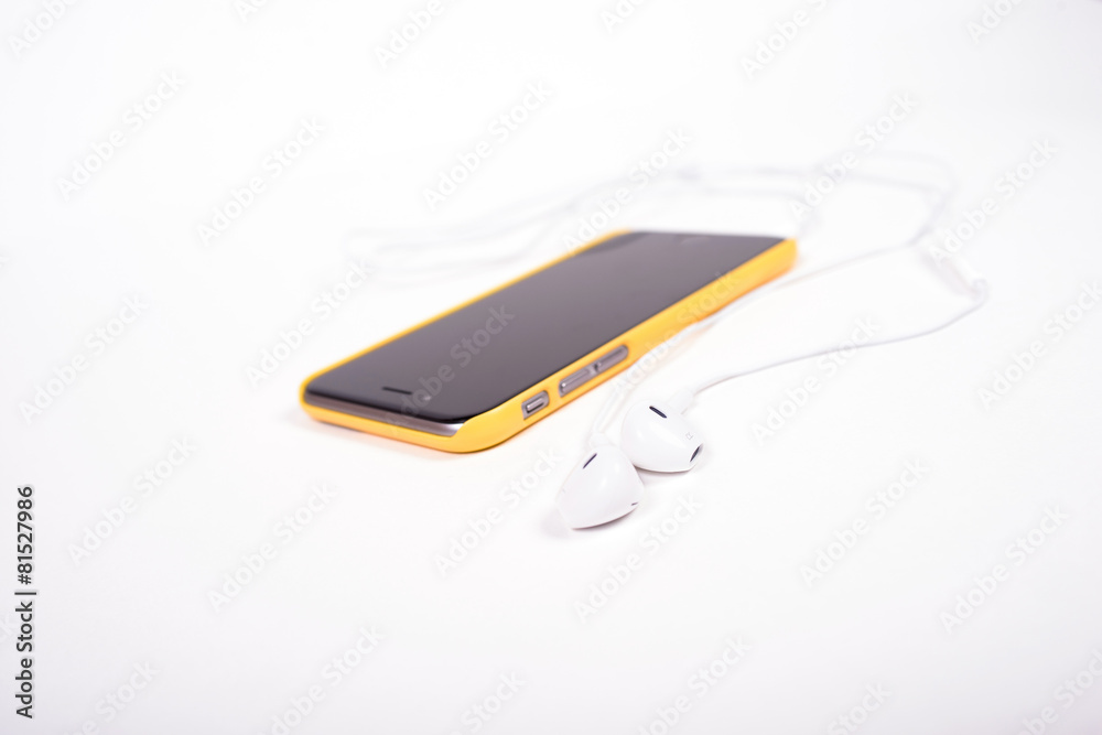 white headphones connected to black phone in yellow case white headphones connected to black phone in yellow case