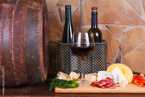 Fototapeta Naklejka Na Ścianę i Meble -  Glass and bottle of wine, cheese and prosciutto