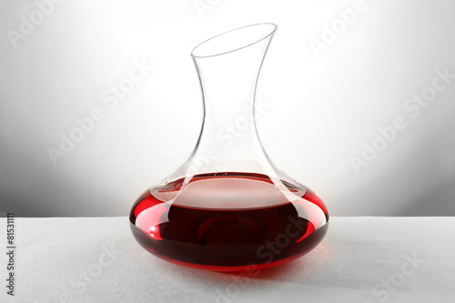 Glass carafe of wine on light background photo