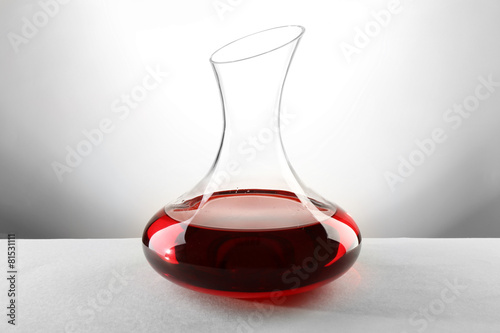 Tableau sur toile Glass carafe of wine on light background