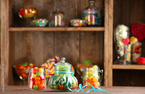 Colorful candies in jars on table in shop