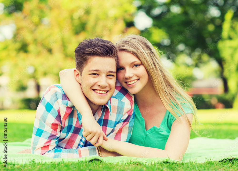 smiling couple lying on blanket in park smiling couple lying on blanket in park