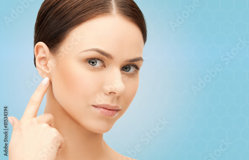 face of beautiful woman touching her ear photo