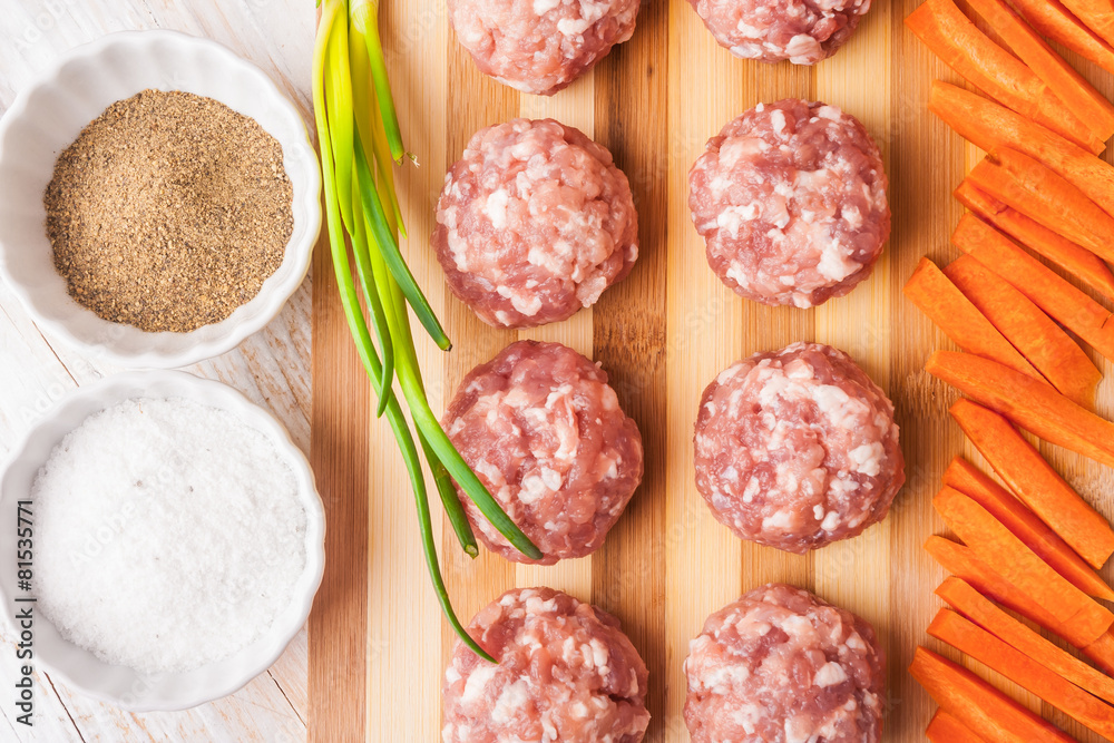 raw meatballs with minced meat on kitchen boardl