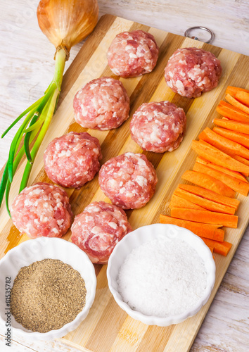 raw meatballs with minced meat on kitchen boardl