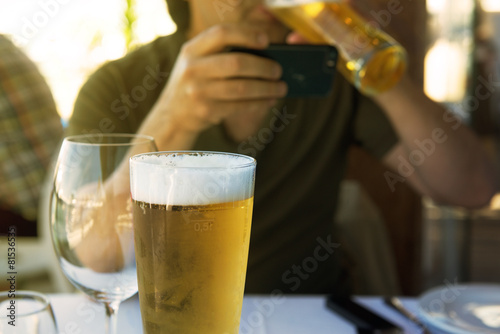 Man drinking beer and reading mobile