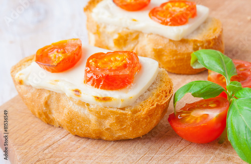 toasts with feta cheese and tomatoes on the kitchen board