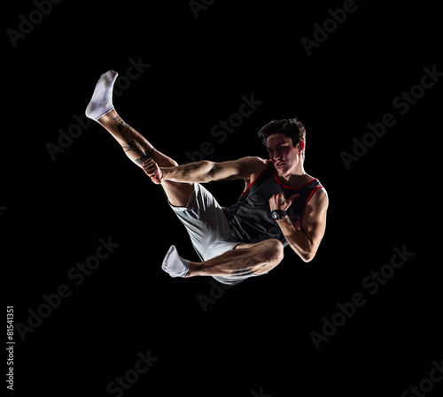 Isolated black young man is jumping on trampoline