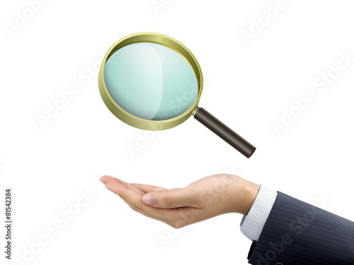 businessman's hand holding magnifying glass