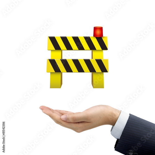 businessman's hand holding road barrier