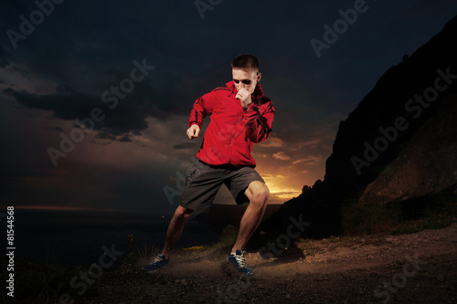 Man running in the mountains at night. © kuznetsov_konsta