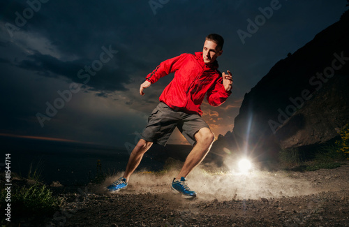 Man running in the mountains at night. © kuznetsov_konsta