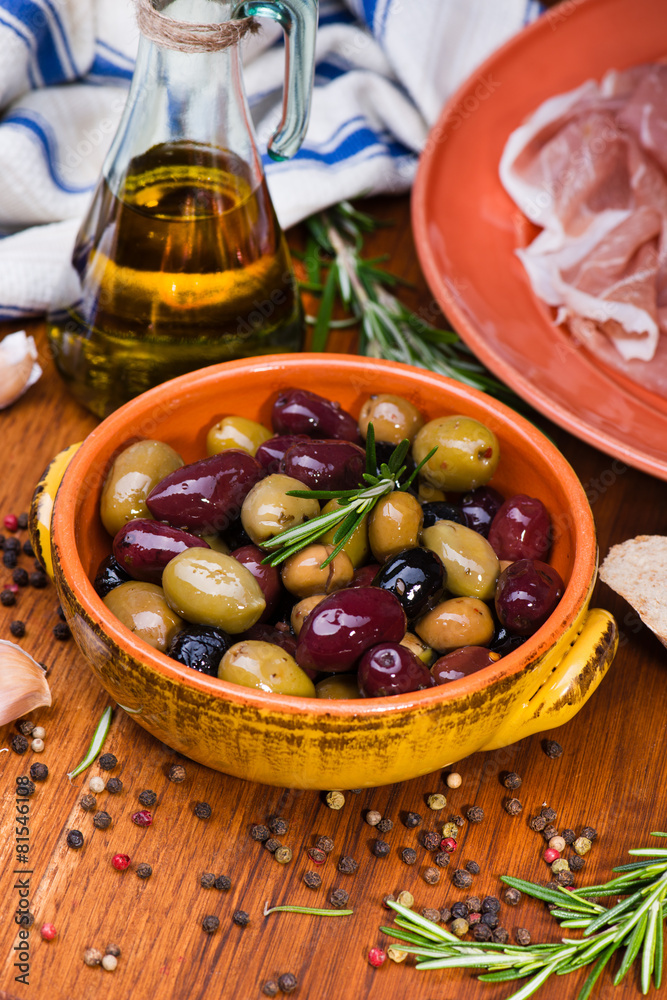 Olives in bow with prosciutto on wooden table Olives in bow with prosciutto on wooden table