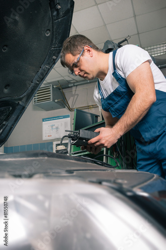 Professional car mechanic working in auto repair service
