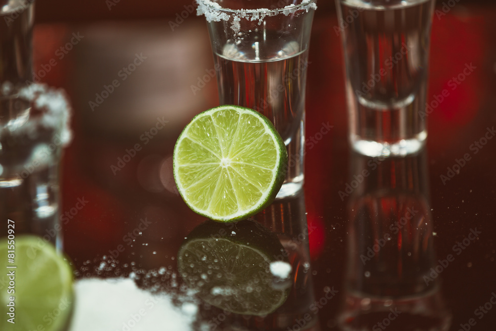 shots of tequila with lime and salt on a wooden table bar shots of tequila with lime and salt on a wooden table bar