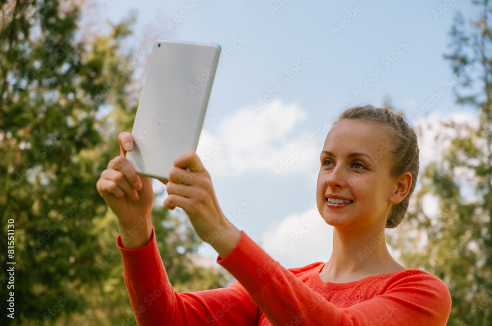Young woman making selfie with tablet in green park Young woman making selfie with tablet in green park