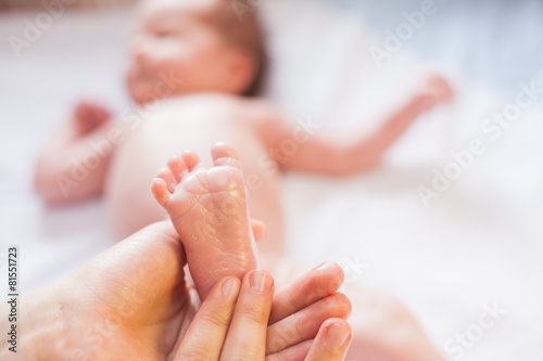 Mother makes massage for happy baby